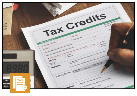 Tax credits form on a desk with a calculator and a person filling out details using a pen.